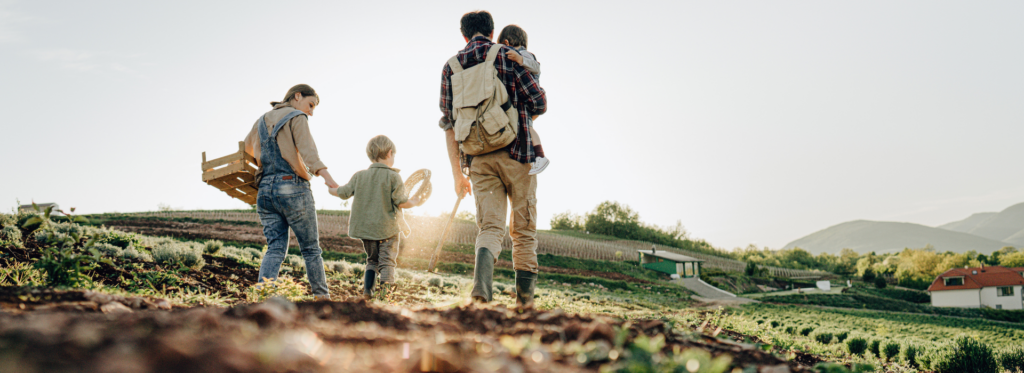 A family walking together on farmland, symbolizing generational wealth transfer.